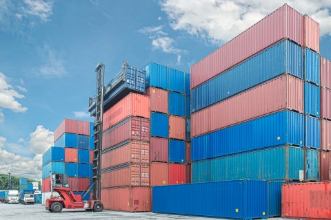 forklift handling container box loading to truck in import export logistic zone